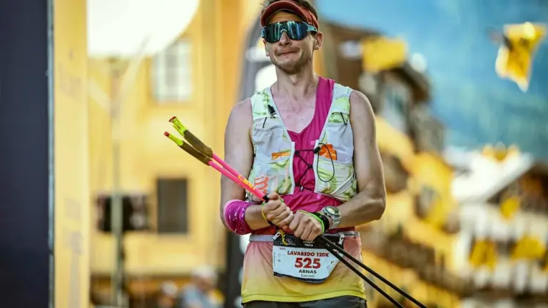 Bėgikas su sportine apranga, akiniais ir lazdomis dalyvauja Lavaredo kalnų ultramaratone Italijoje.