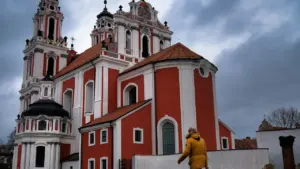 Pėsčiasis praeina pro Šv. Kotrynos bažnyčią Vilniaus senamiestyje apniukusią dieną.