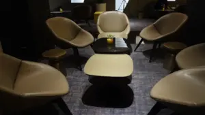 Moderni oro uosto verslo klasės poilsio zona su patogiais krėslais ir staliukais.