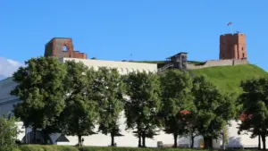 Gedimino pilies bokštas Vilniuje apsuptas žalumos giedrą vasaros dieną