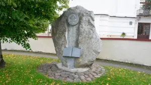 Didelis akmuo su atversta knyga ant jo žaliuojančioje Pakruojo rajono pievoje