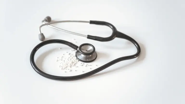 Medicininis stetoskopas ant balto pagrindo atstovaujantis profesionalią medicinos priežiūrą ir konsultacijas.