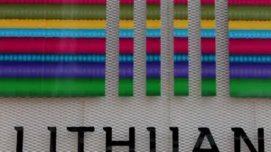 Lietuvos pavadinimo fragmentas ant spalvingo stendo, reprezentuojantis šalies identitetą ir oficialų kontekstą.